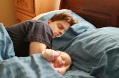 dad sleeping next to young baby